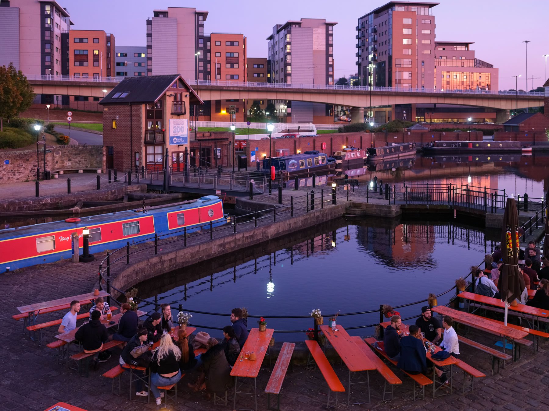 People enjoying a drink, in the evening, around the canal basin at Victoria Quays.