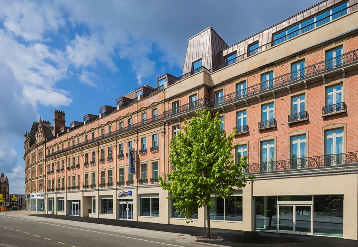 Exterior of the Radisson Blu hotel with trees in front.
