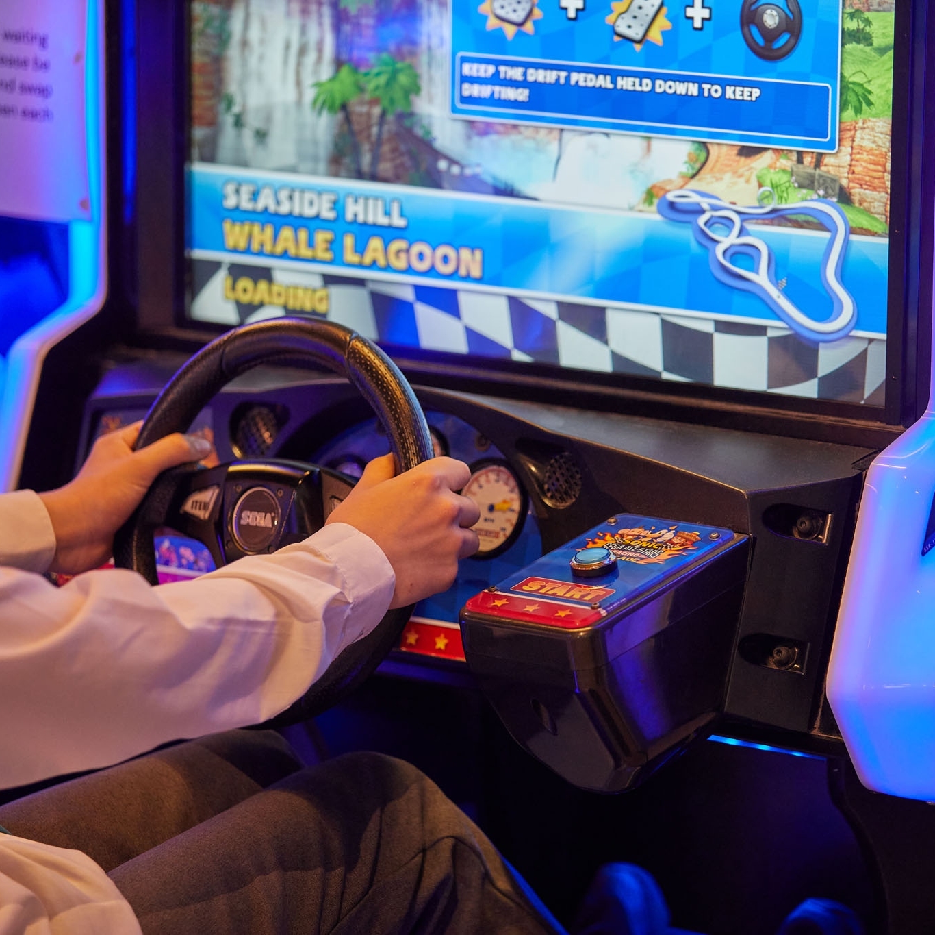 A person playing a driving game at The National Videogame Museum.