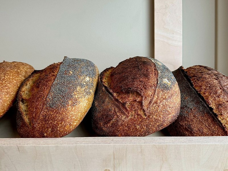 A shelf full of freshly baked bread at Bench La Cave .