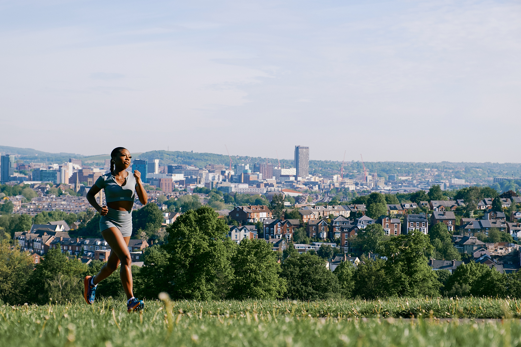 Runner in Meersbrook Park with cityscape view in the background