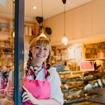 A smiling member of staff opening the door to Cocoa Wonderland.