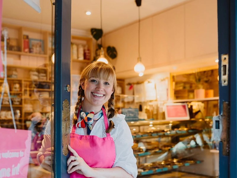 A smiling member of staff opening the door to Cocoa Wonderland.