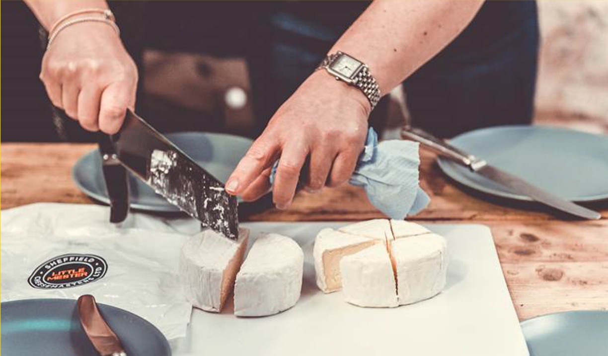 A close-up of some cheeses being cut up on a chopping board.