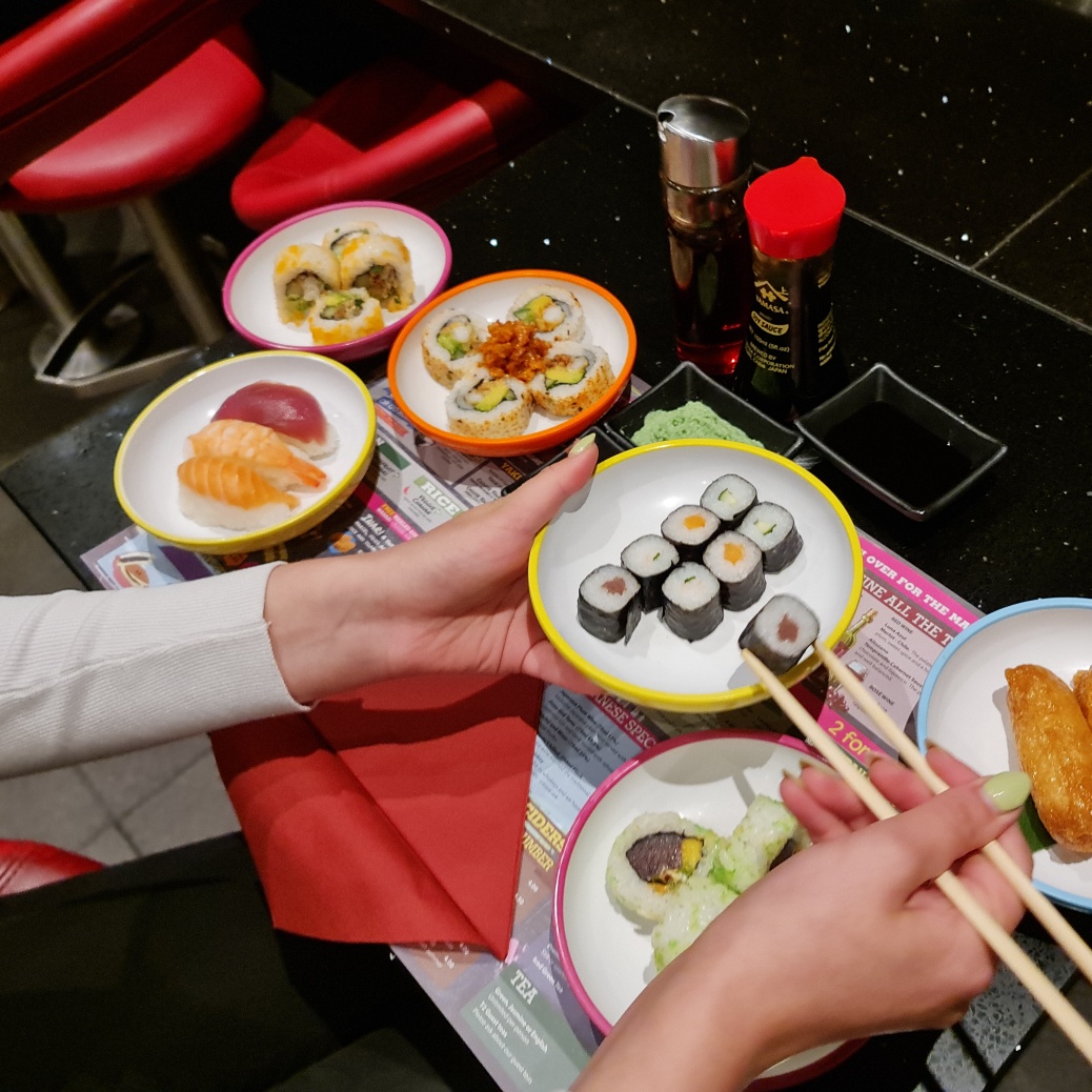 A person eating Japanese food with chopsticks.