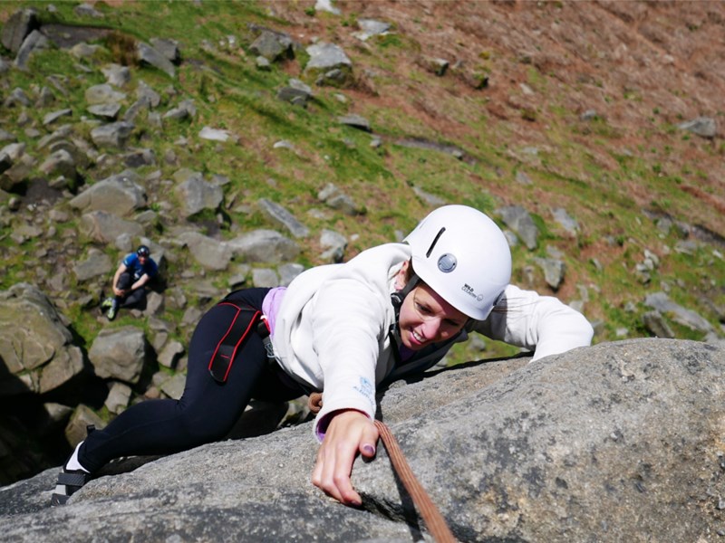 A woman climbing a rock face.