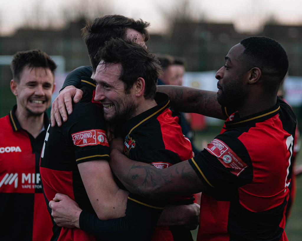 Sheffield FC players hugging.