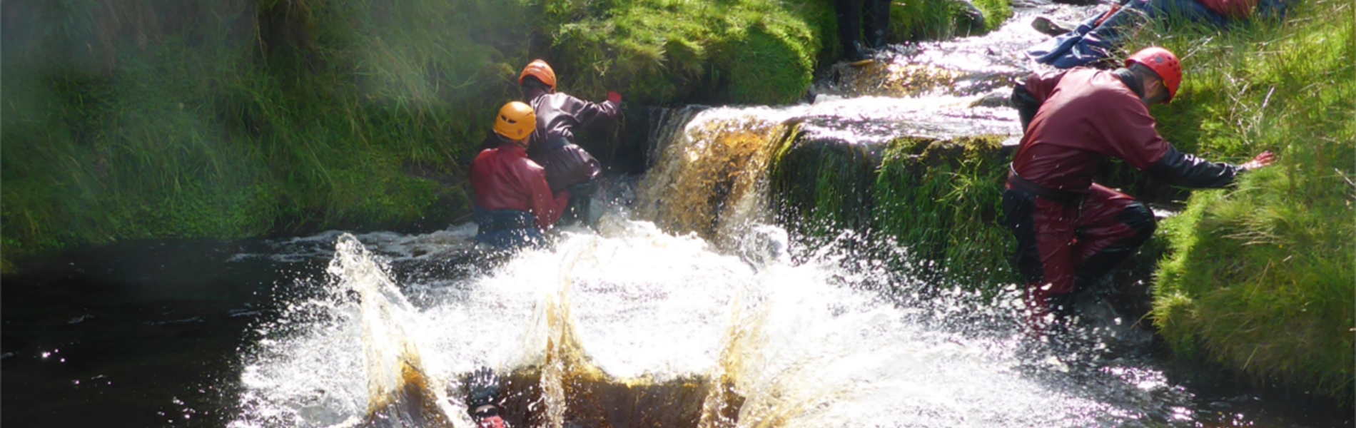 People training in a river, all of whom are wearing safety gear.