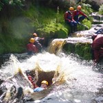People training in a river, all of whom are wearing safety gear.