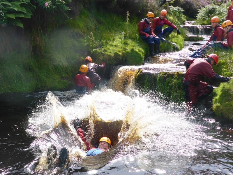 People training in a river, all of whom are wearing safety gear.