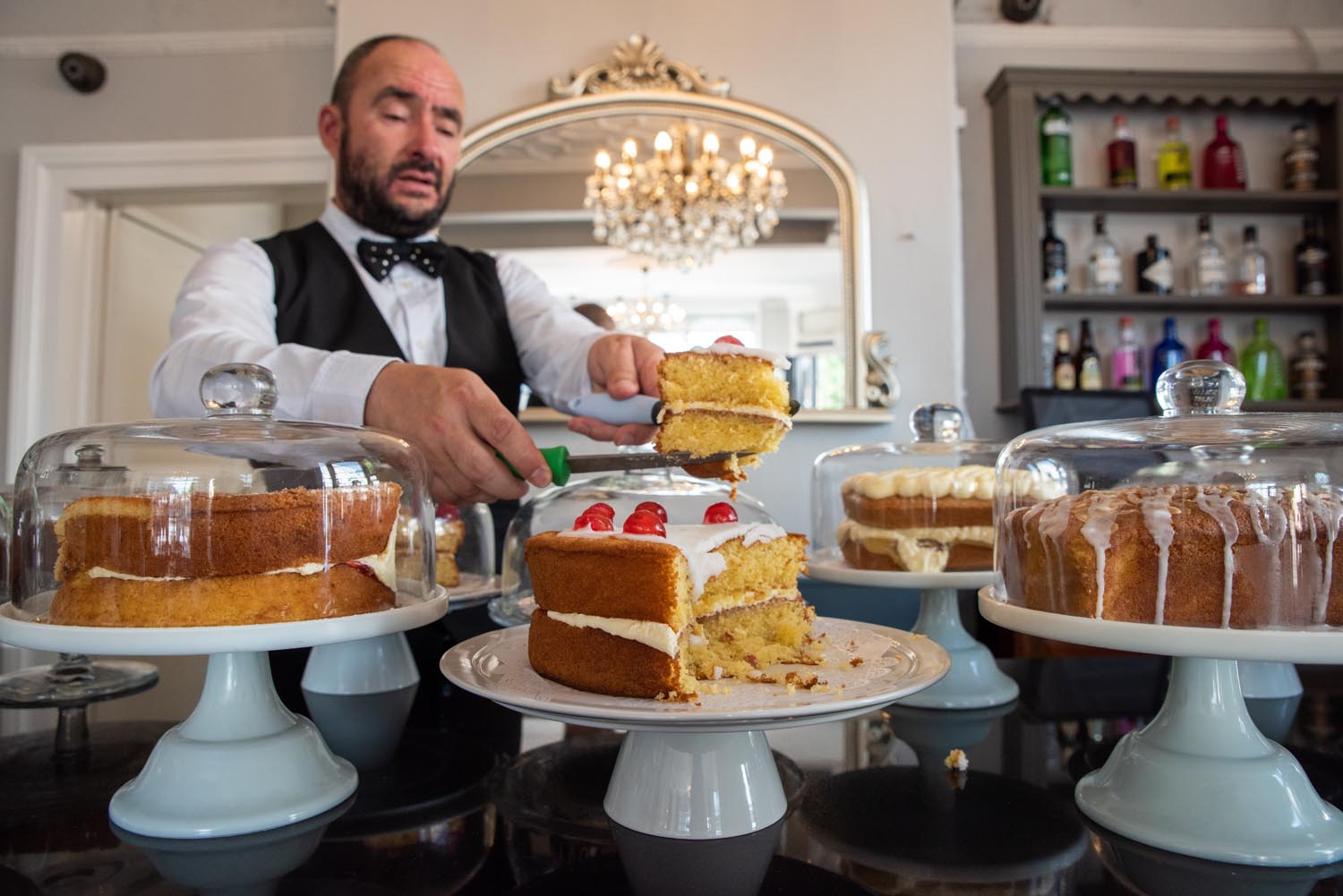 A member of staff cuts a slice of cake at Jameson's Tea Room.