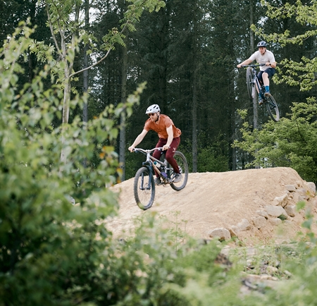 Mountain bike riders on a jump at Wharnecliffe and Greno Woods.