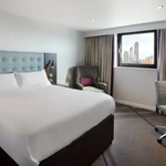 Hotel room with a double bed featuring soft furnishings and decorative cushions.