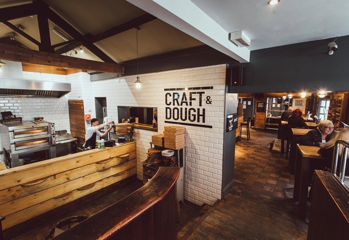 The interior of Craft And Doug with a view of the kitchen and the seating area.