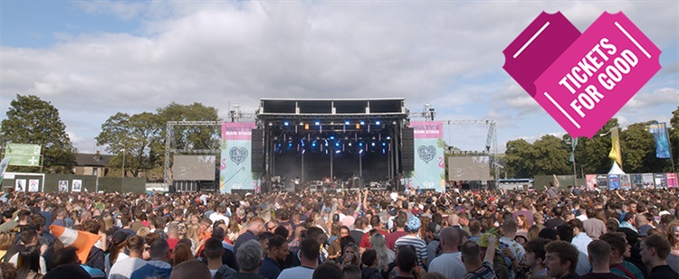 A crowd at a music festival in front od a stage.