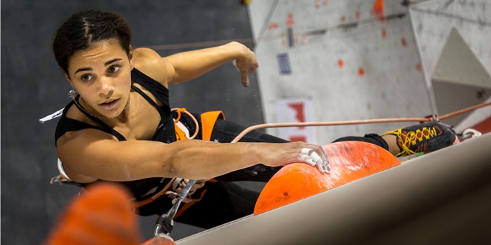 A woman climbing on an indoor climbing wall.