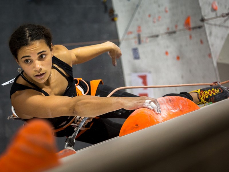 A woman climbing on an indoor climbing wall.