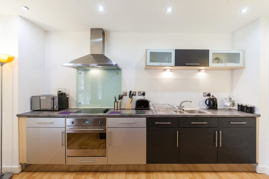 Kitchen area with countertops, cabinets, sink, and appliances, arranged for functional cooking and dining.