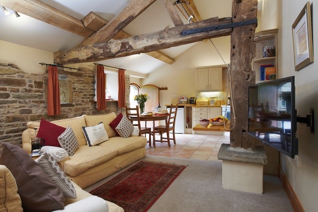 The living room in a small boutique hotel, with beams on the ceilings and stone walls.