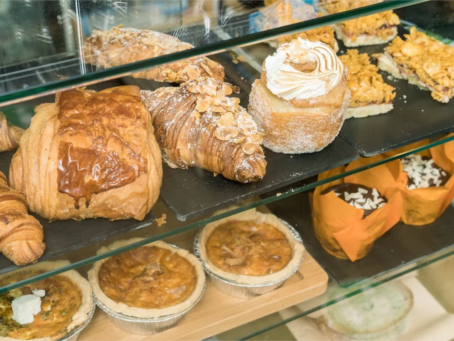 A glass case filled with pastries and baked goods.