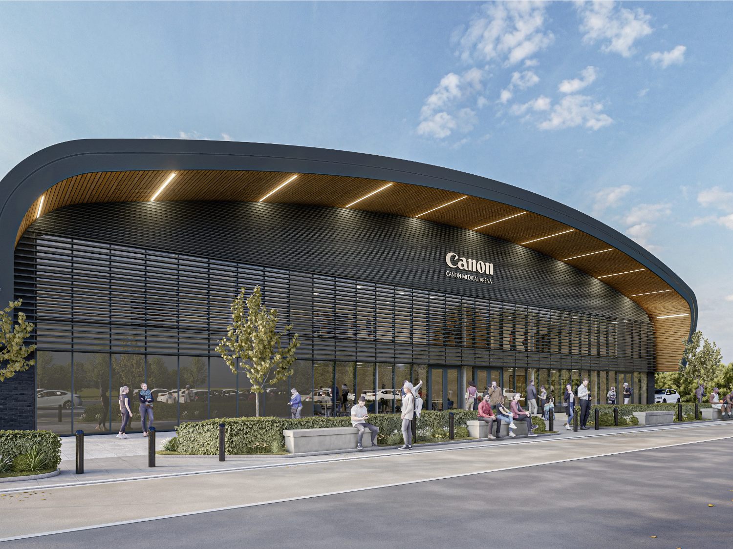 The exterior of the Canon Medical Arena, a building made of glass and steel with a gently curved roof.