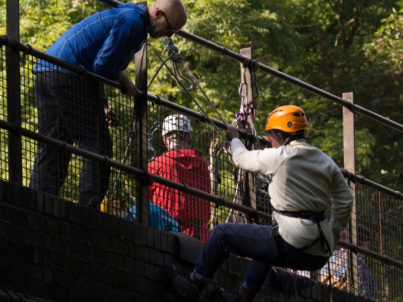 People abseiling off a bridge.