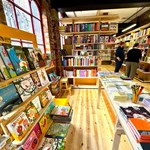 The interior of La Biblioteka bookshop, with all the walls lined with wooden shelves filled with books for sale.