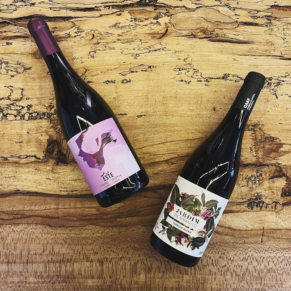 Two bottles of wine lying flat on a wooden surface.