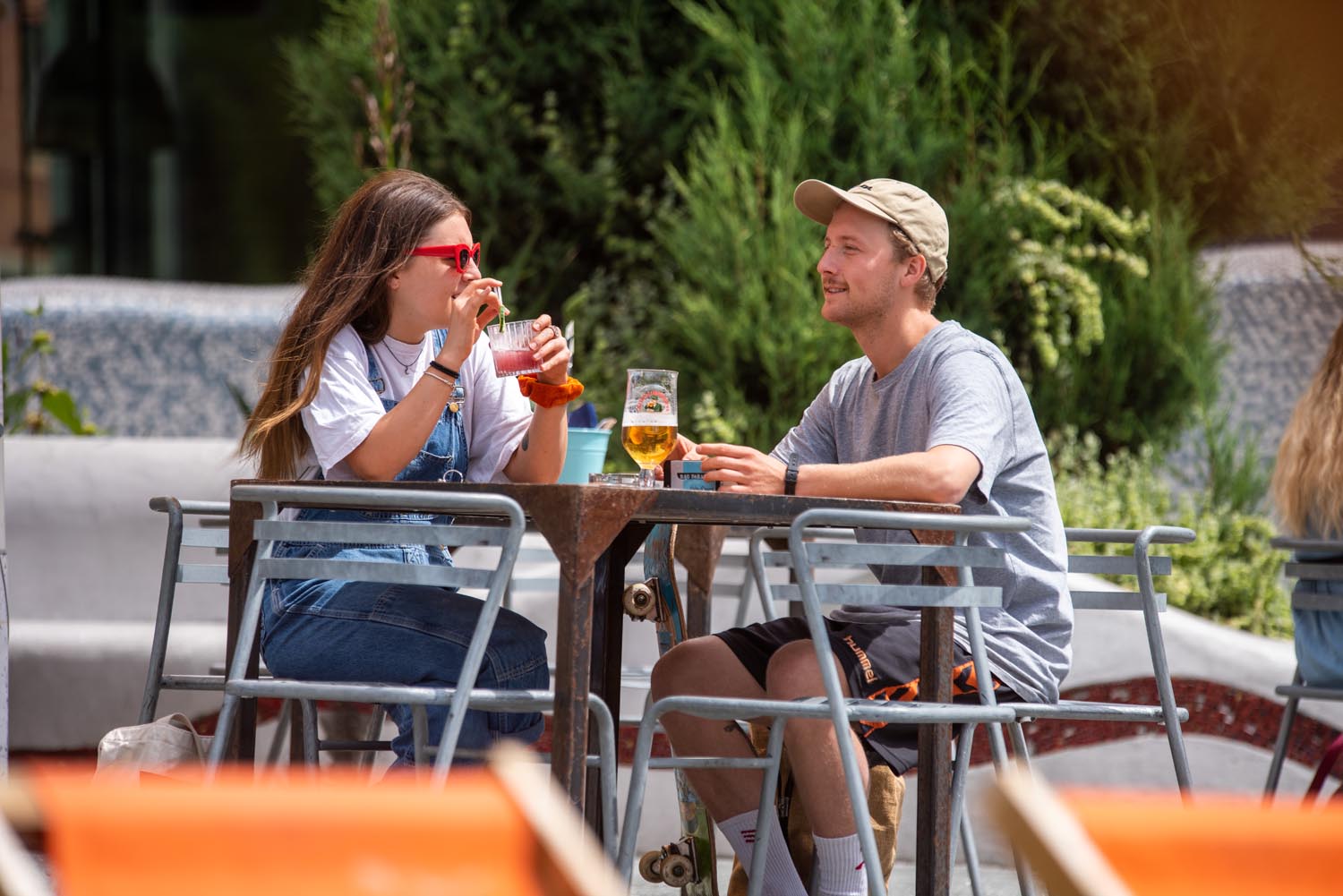Two people having a drink in the outdoor seating area at Forum Kitchen + Bar.