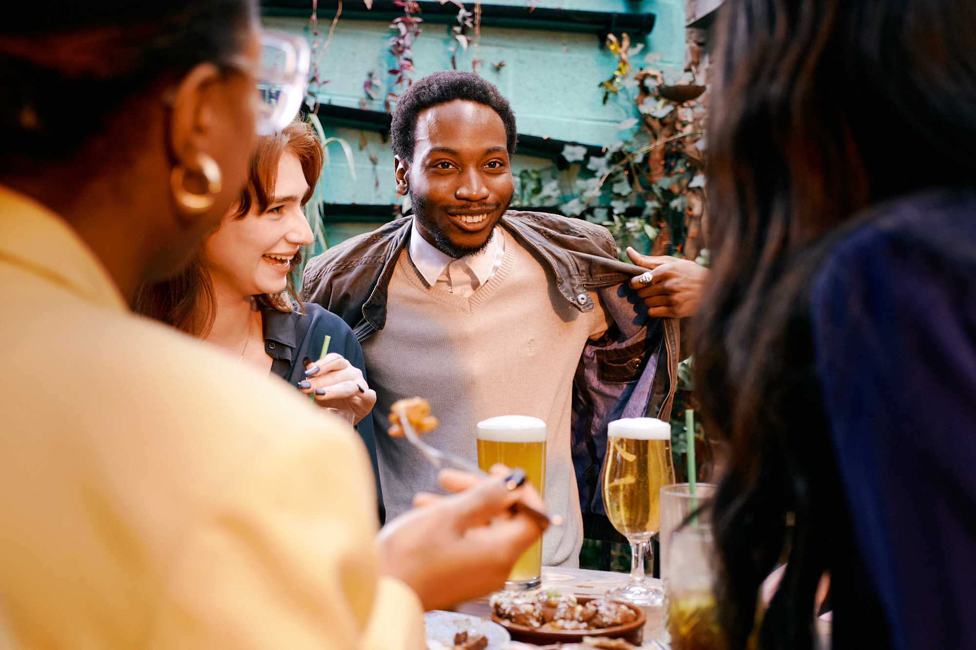A group of friend enjoy drinks and a bite to eat.