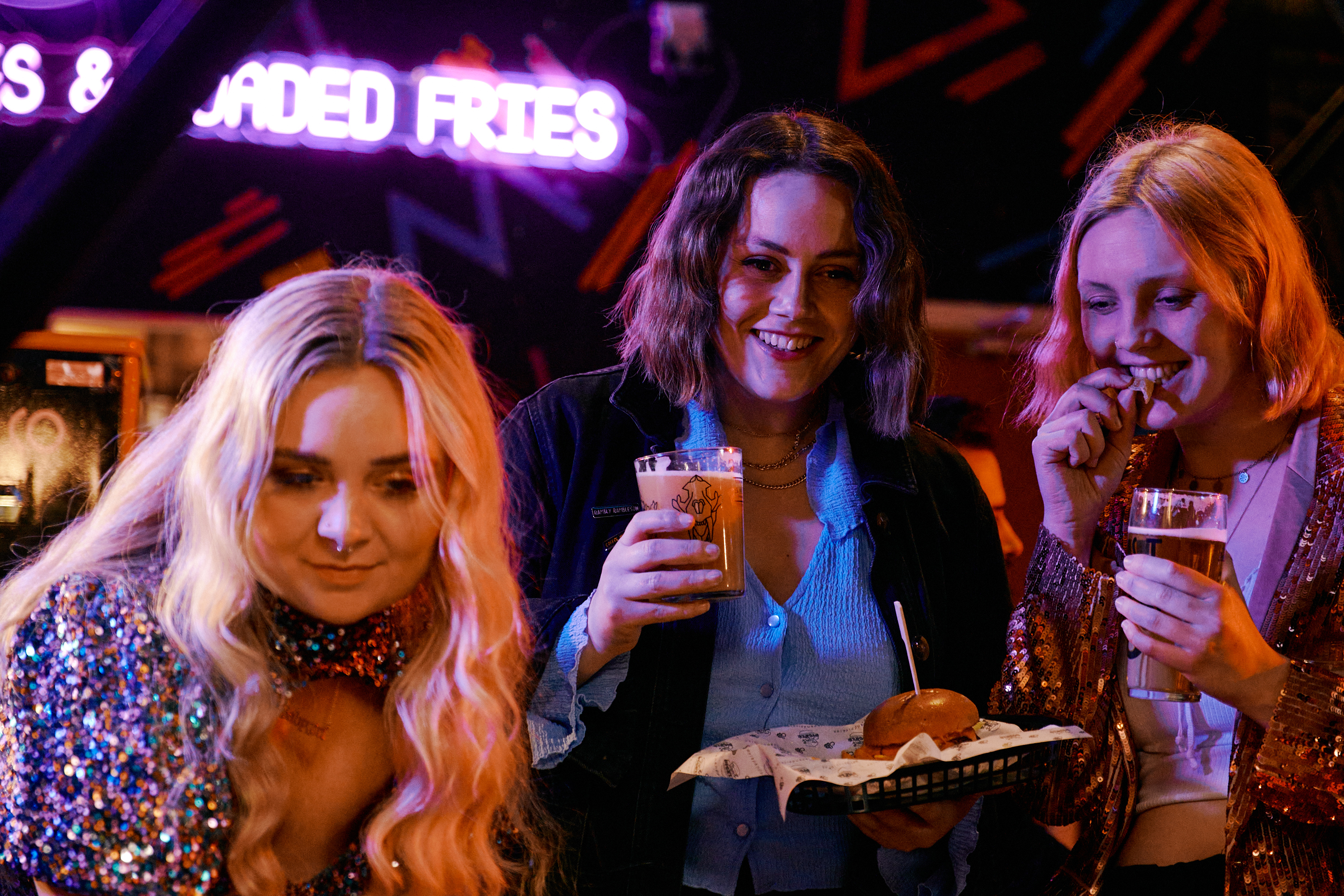 Three women enjoying something to eat and drink at a night spot in Sheffield.
