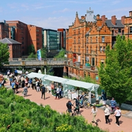 Crowds of people are walking around and shopping at Pollen Market, an outdoor flower market that is held once a month.