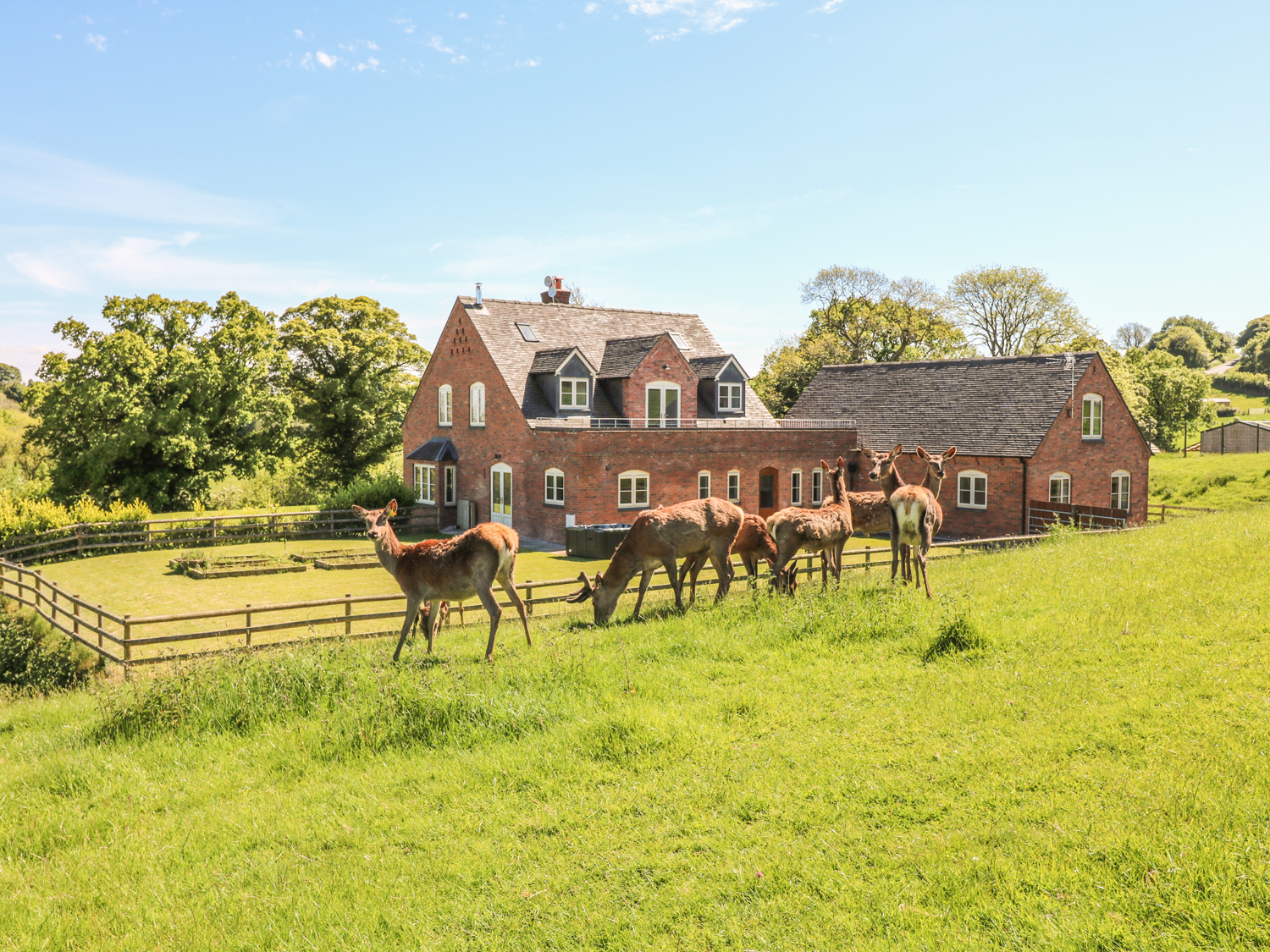 Exterior view of a Sykes Holiday Cottage with front garden and countryside surroundings.