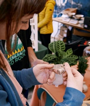 Girl looking at tag of item on plant stall