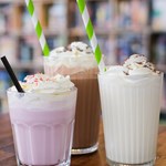 Three fancy milkshakes, with cream and sprinkles.