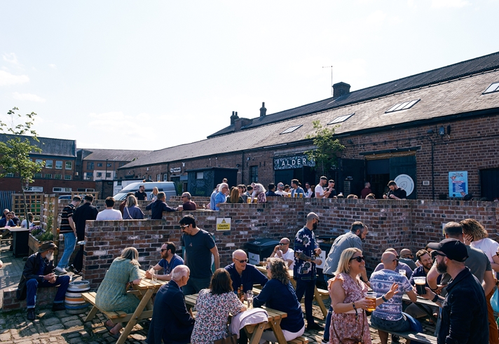 Courtyard full of people socialising in sunshine at Alder Bar in Kelham Island