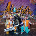 The cast of the Lyceum Panto Aladdin pose in a group shot with arms wide and joyful expressions