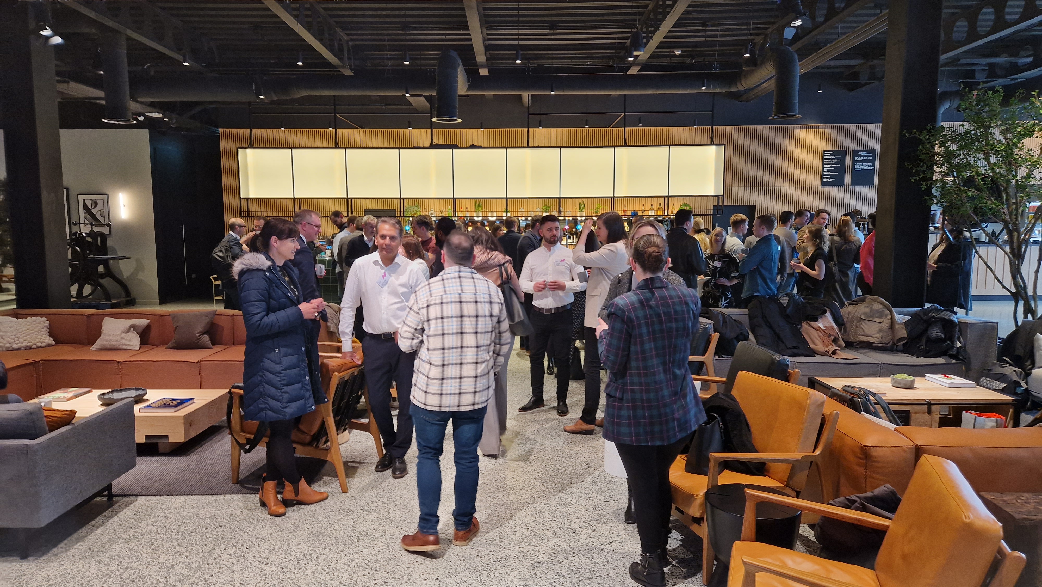 A conferencing space is filled with people chatting.