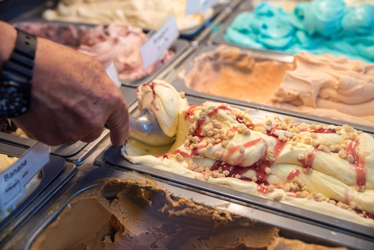 Rows of tubs of different flavour ice creams.