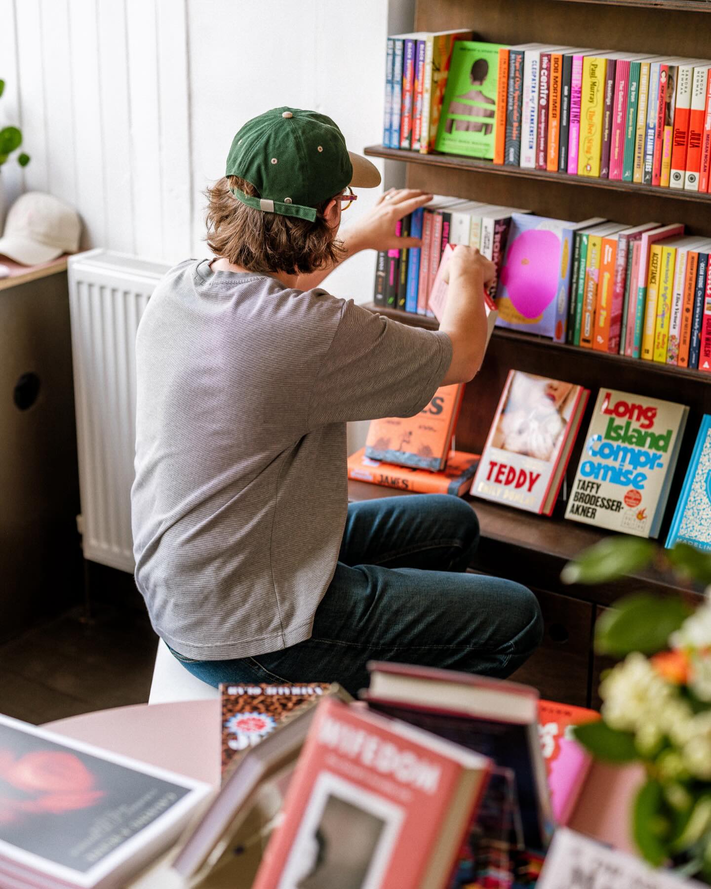 A man stocking a shelf in a book shop.