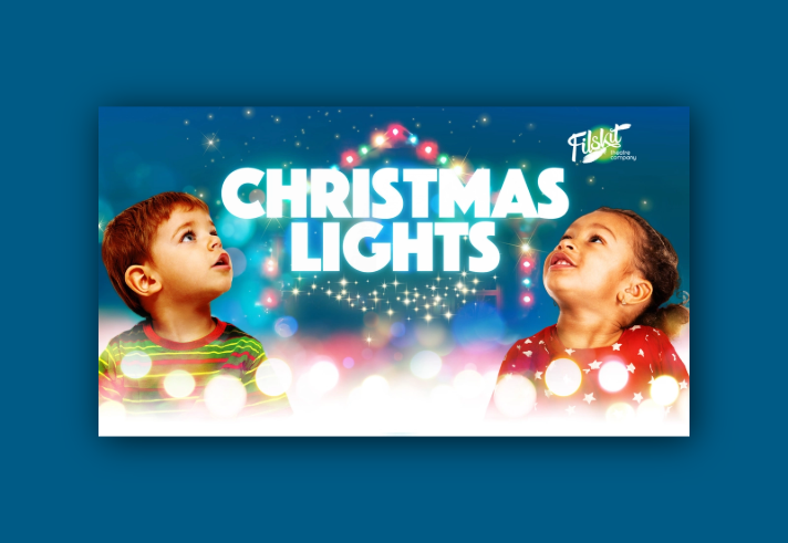 Two small children are looking in wonder at Christmas lights.