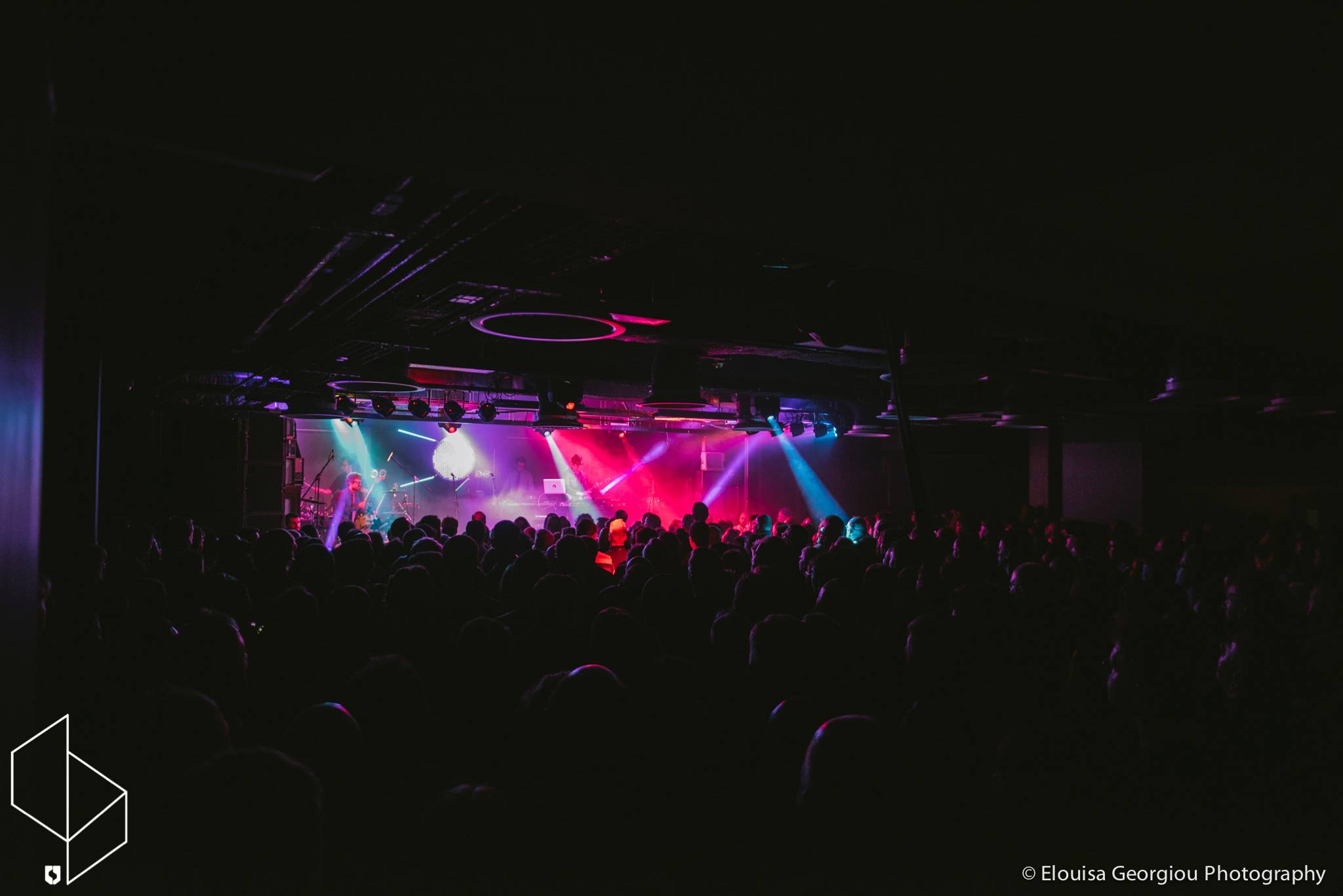 A band plays live on stage in front of an audience.