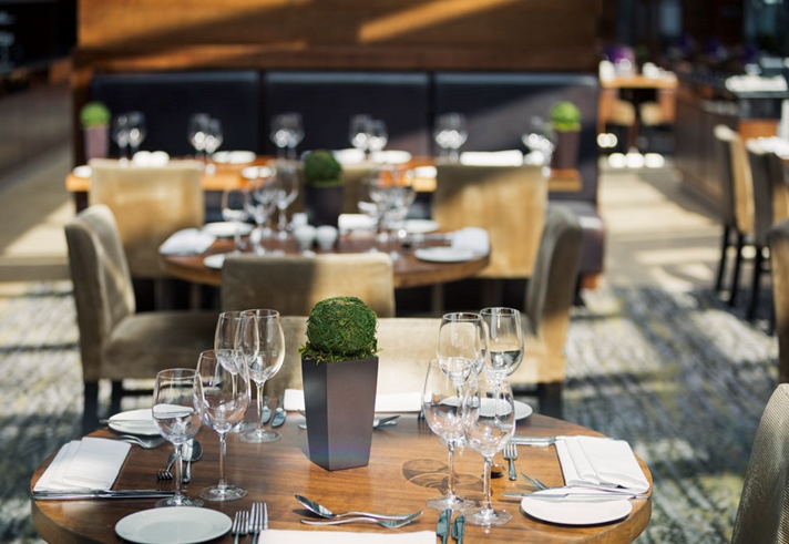 Elegantly set tables in the restaurant at Mercure St Paul's, featuring glassware and cutlery.