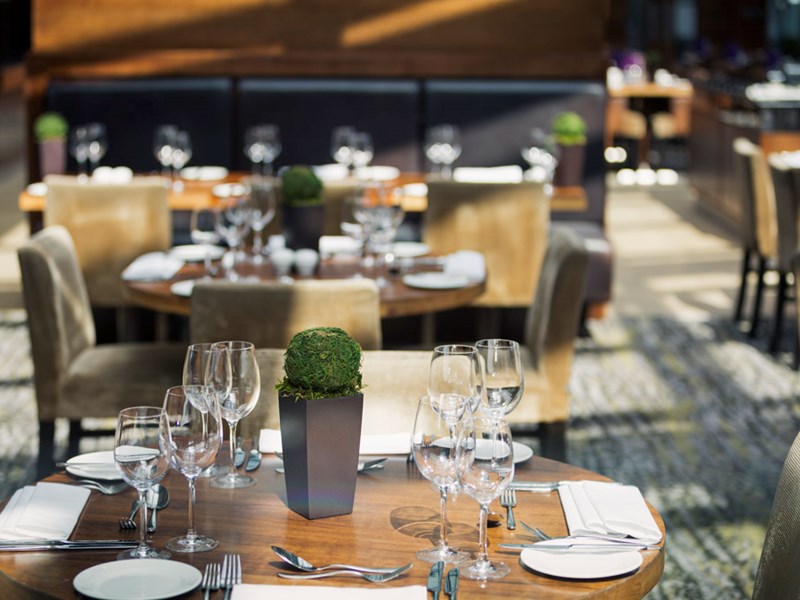 Elegantly set tables in the restaurant at Mercure St Paul's, featuring glassware and cutlery.