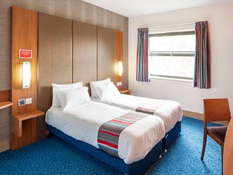 Interior of a twin room at Travelodge Sheffield Meadowhall with two single beds and modern furnishings.