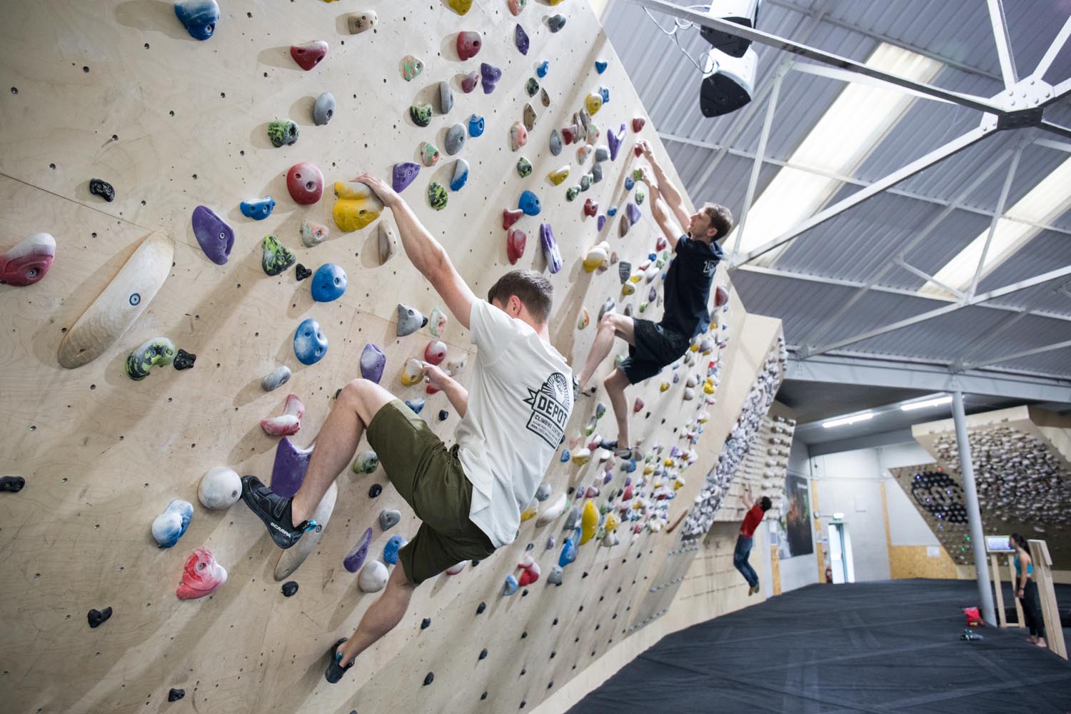 Two people on a climbing wall at Depot Climbing.