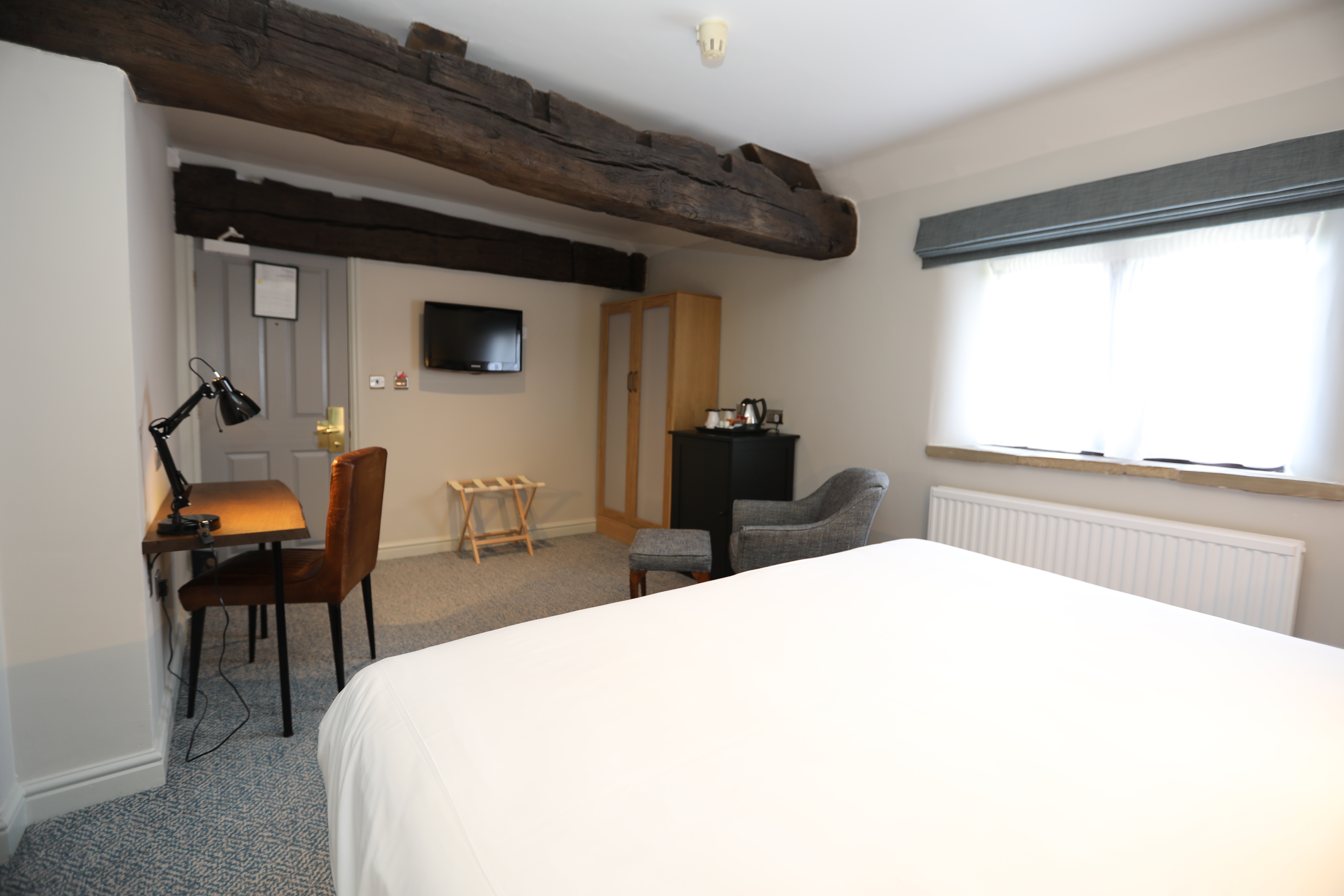edroom at Mercure Tankersley Manor featuring a bed and a small living area with chairs and a table.