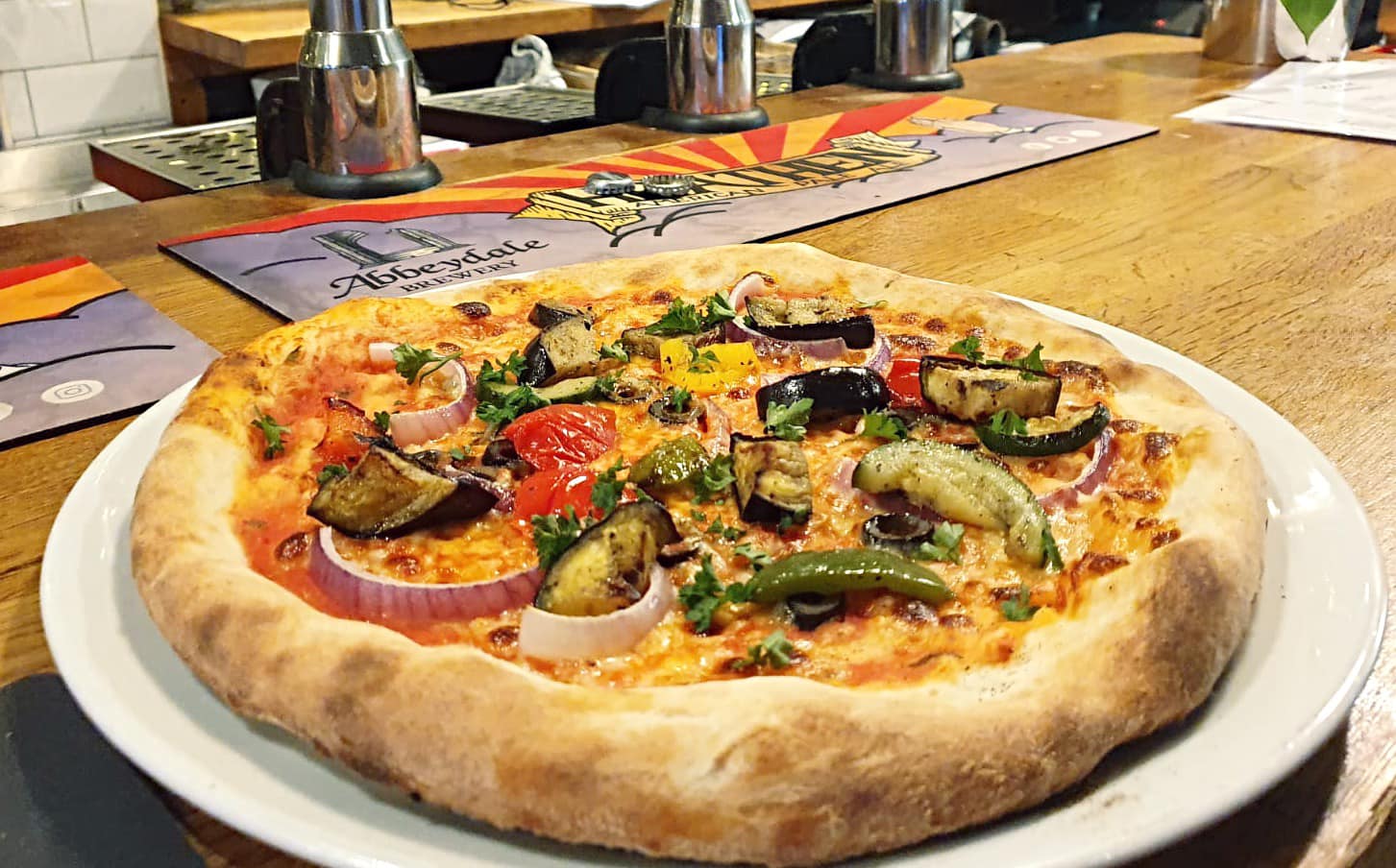 A thick crust pizza on a white plate.