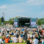 View from the back of the crowd sat out in front of the Tramlines main stage on a sunny summer's day