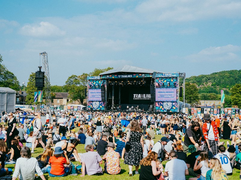 View from the back of the crowd sat out in front of the Tramlines main stage on a sunny summer's day